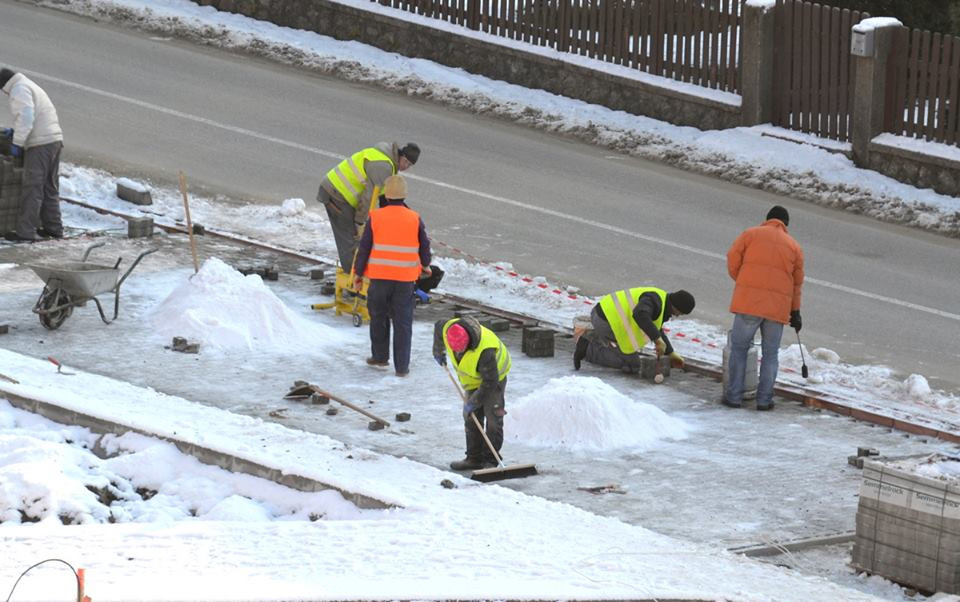 Muncitori filmați în timp ce pavau pe ger, cu ajutorul unei butelii