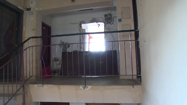 Uşa unei garsoniere, smulsă din perete de o explozie. Locatarul, în stare critică