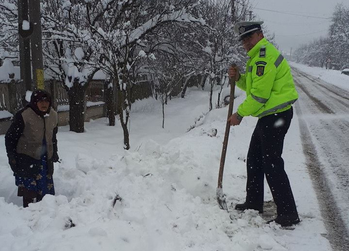 Bătrână izolată în curte din cauza zăpezii, ajutată de un polițist, în Gorj