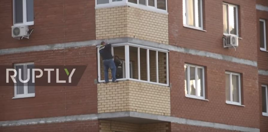Momentul în care un bărbat montează o fereastră la etajul al 12-lea fără siguranță. VIDEO