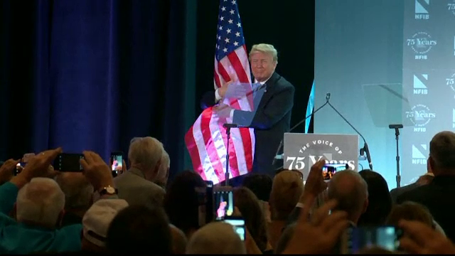 Donald Trump a îmbrăţişat steagul aflat pe o scenă. Glumele apărute pe internet