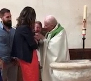 Un preot a lovit un bebeluș în timpul unei ceremonii de botez, pentru a-l opri din plâns. VIDEO