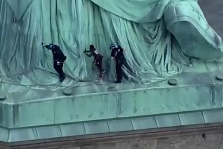 O femeie s-a căţărat pe Statuia Libertăţii. Ce mesaj a vrut să transmită. VIDEO