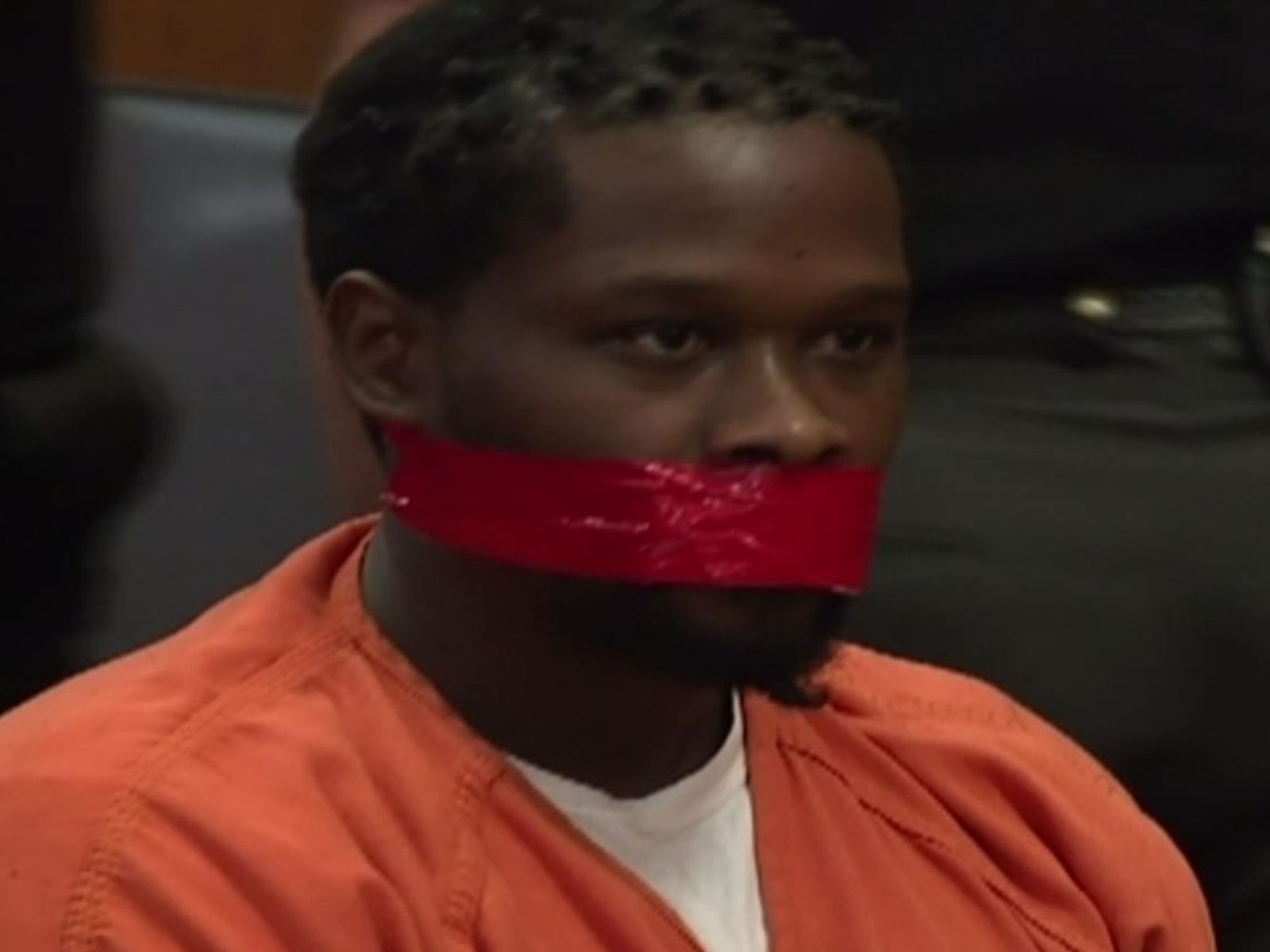 Gestul unui deținut în sala de judecată. Polițiștii i-au lipit bandă adezivă pe gură