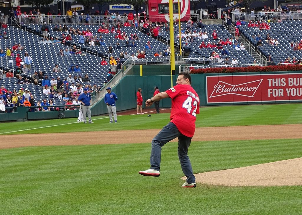 George Maior, chemat să dea lovitura de start la un meci de baseball în SUA. Drapelul României, prezent pe stadion