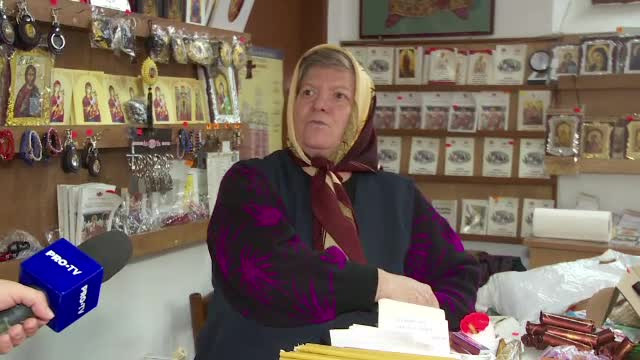 femeie care vinde lumanari la biserica