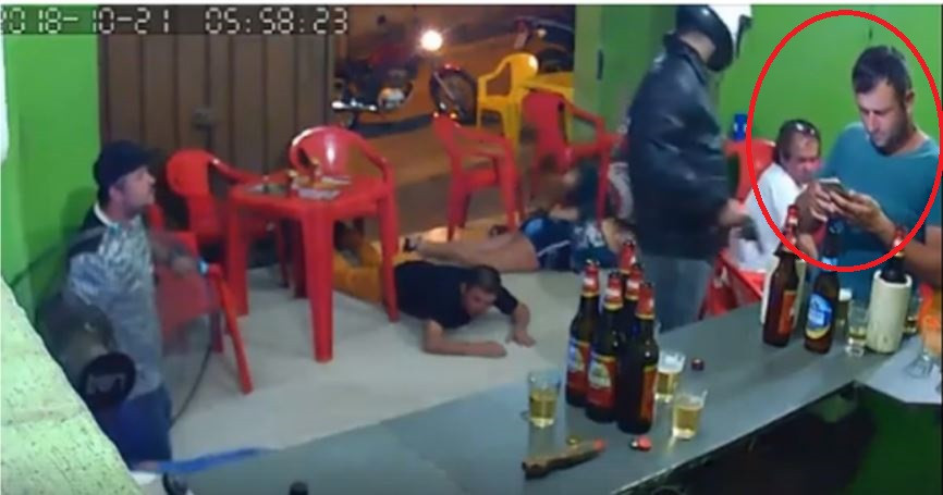 Distras de smartphone, un bărbat nu realizează că se derula un jaf armat în jurul său. VIDEO