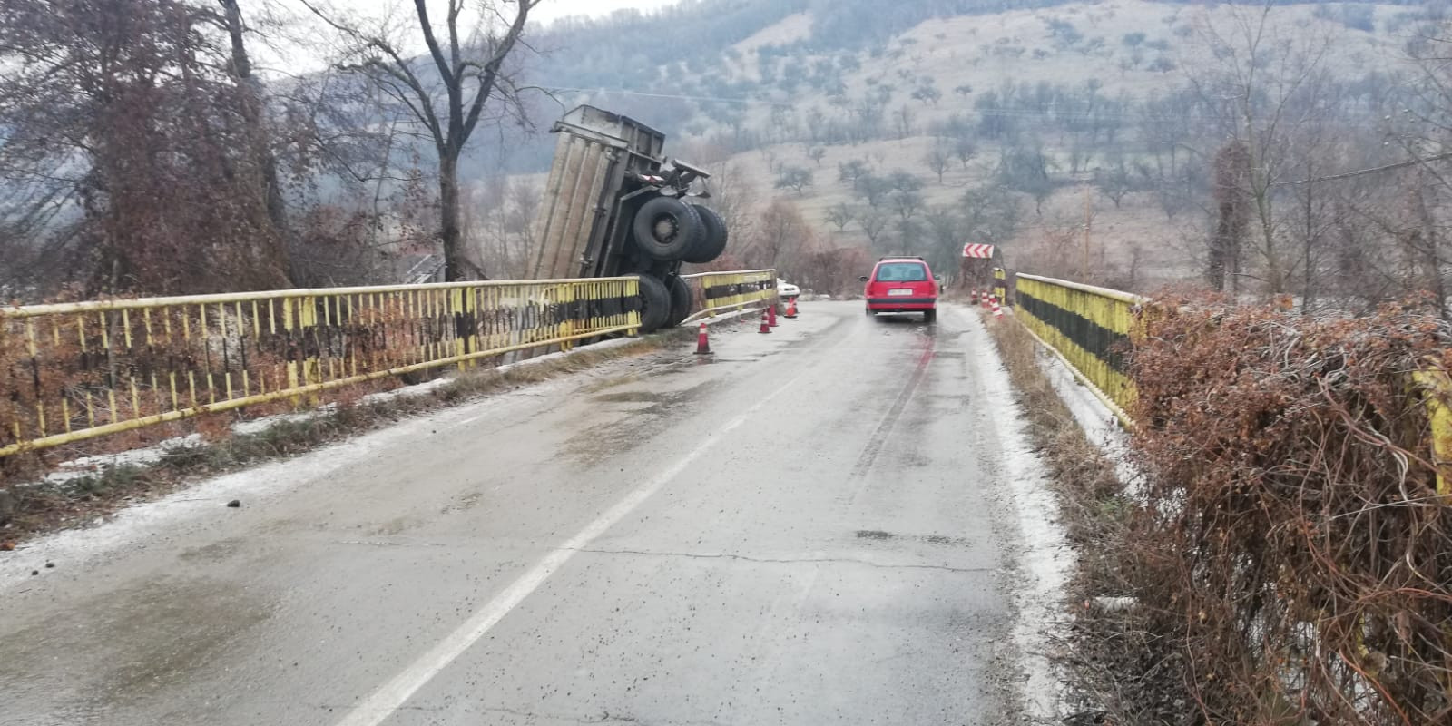 Accident spectaculos în Bistrița, după ce șoferul unei basculante a derapat pe un pod și a căzut în râu