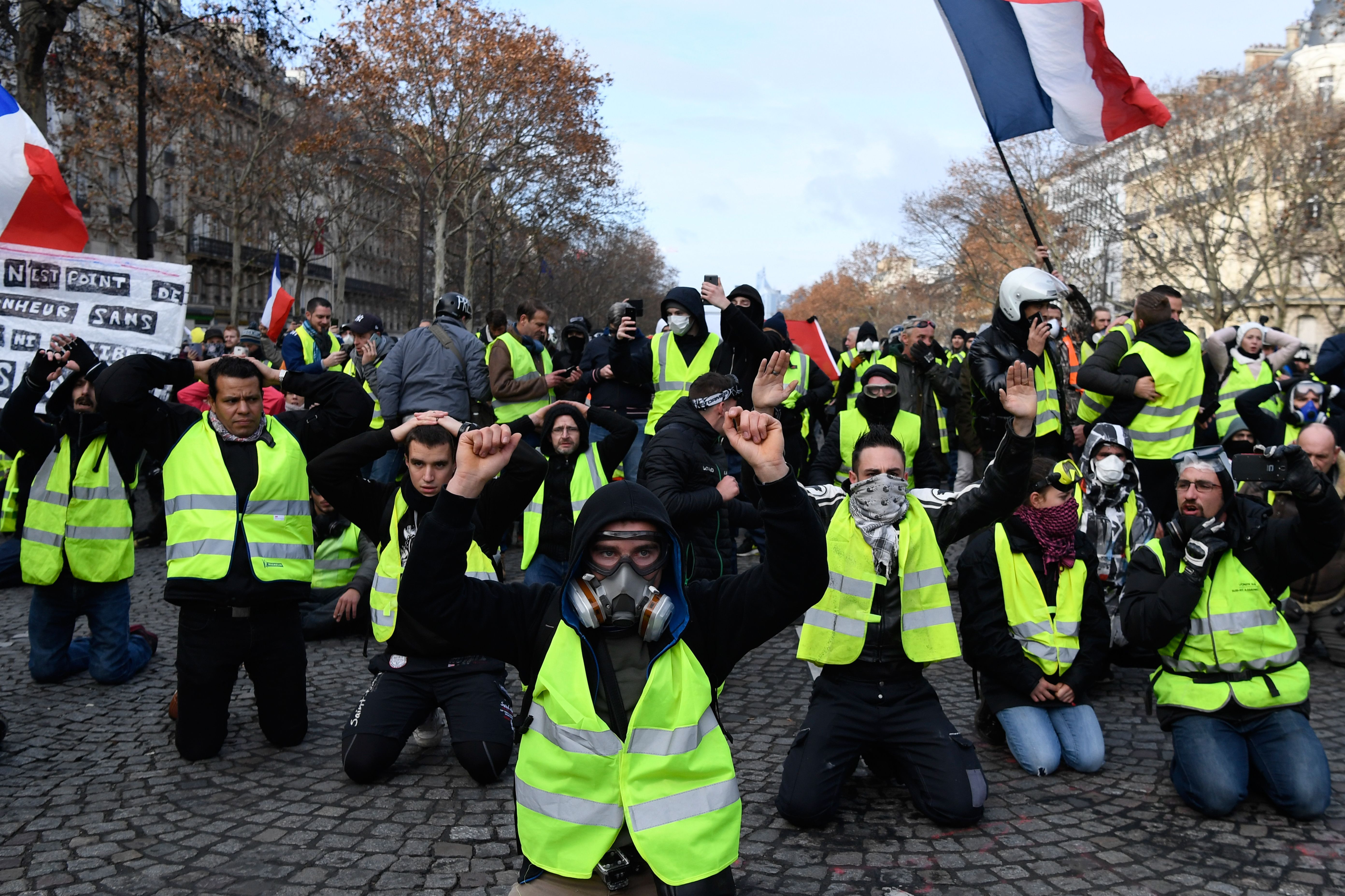 Momentul în care ”vestele galbene” s-au pus în genunchi în fața polițiștilor în Paris. VIDEO