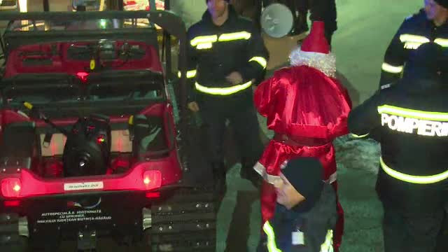Moş Crăciun, adus de pompierii din Bistriţa cu şenilata. Reacţia copiilor