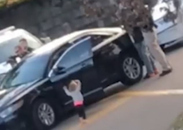 Imagini virale. O fetiță de 2 ani, desculță, cu mâinile ridicate în fața unor polițiști