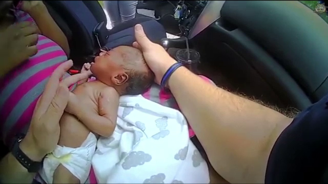 Momentul în care un poliţist salvează de la moarte un bebeluş, surprins de camera video de pe echipament