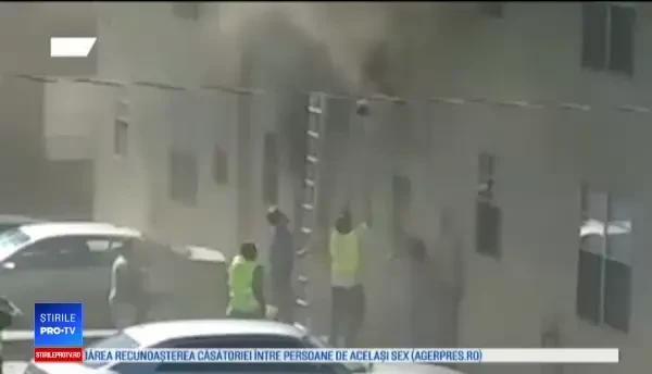 Momentul în care doi muncitori salvează copiii dintr-un apartament în flăcări