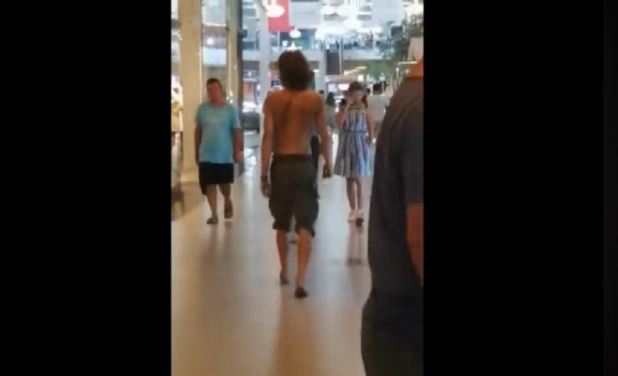 Tânăr dezbrăcat, desculț și cu un cuțit la brâu, filmat într-un mall din Craiova. Reacția poliției