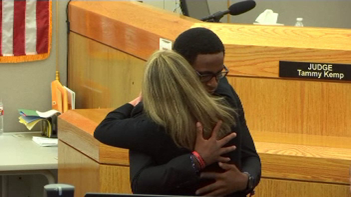 Momentul emoționant în care o polițistă este îmbrățișată de fratele tânărului pe care l-a omorât