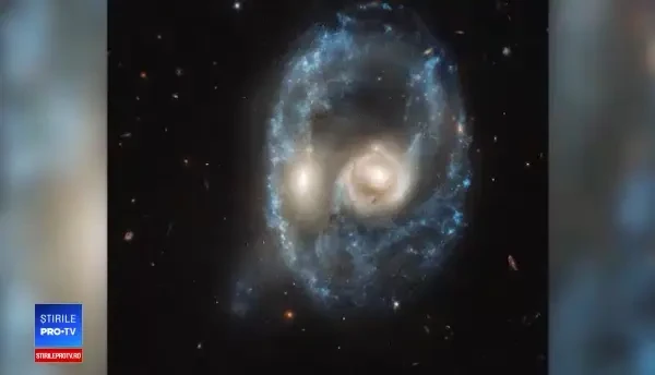 Imagine uimitoare surprinsă în spaţiu. Două galaxii par că formează chipul unui supererou