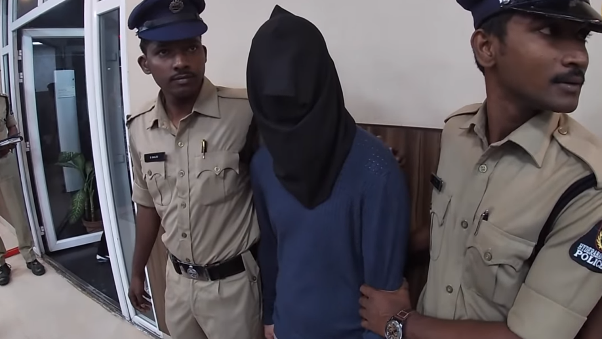 Români arestați pentru terorism cibernetic în India, prezentați cu cagule pe cap