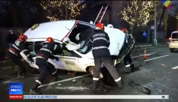 Taxi răsturnat pe o stradă din Baia Mare. Autoturismul a lovit o bordură și a rupt un copac