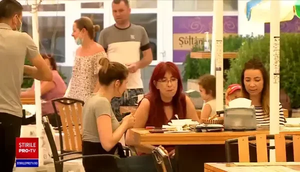 Distanțarea socială îi lasă flâmânzi pe turiști. Fug cu farfuria de mâncare când îi prinde ploaia