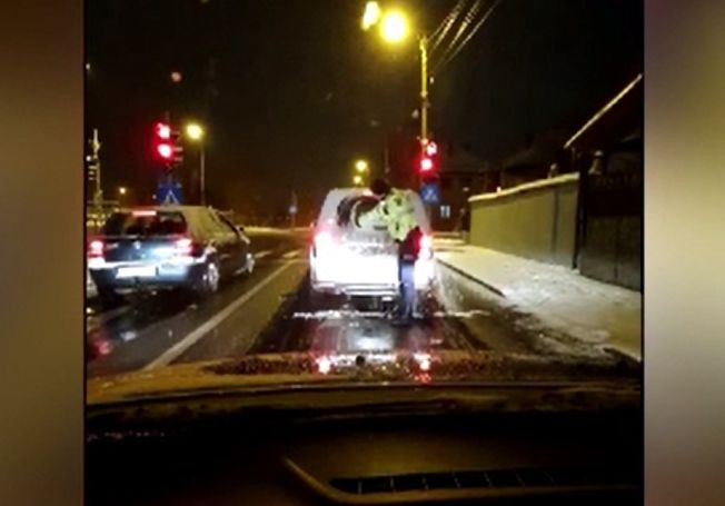 Polițiștii care s-au bătut cu zăpadă au curăţat apoi luneta unui şofer, în trafic. Reacţia acestuia