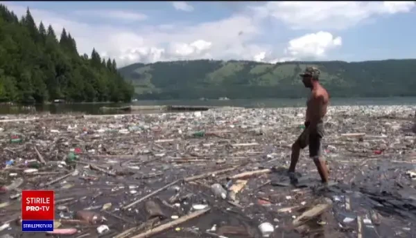 Viiturile și nepăsarea față de mediu. Oamenii înoată printre deșeuri ca să ajungă la bărci