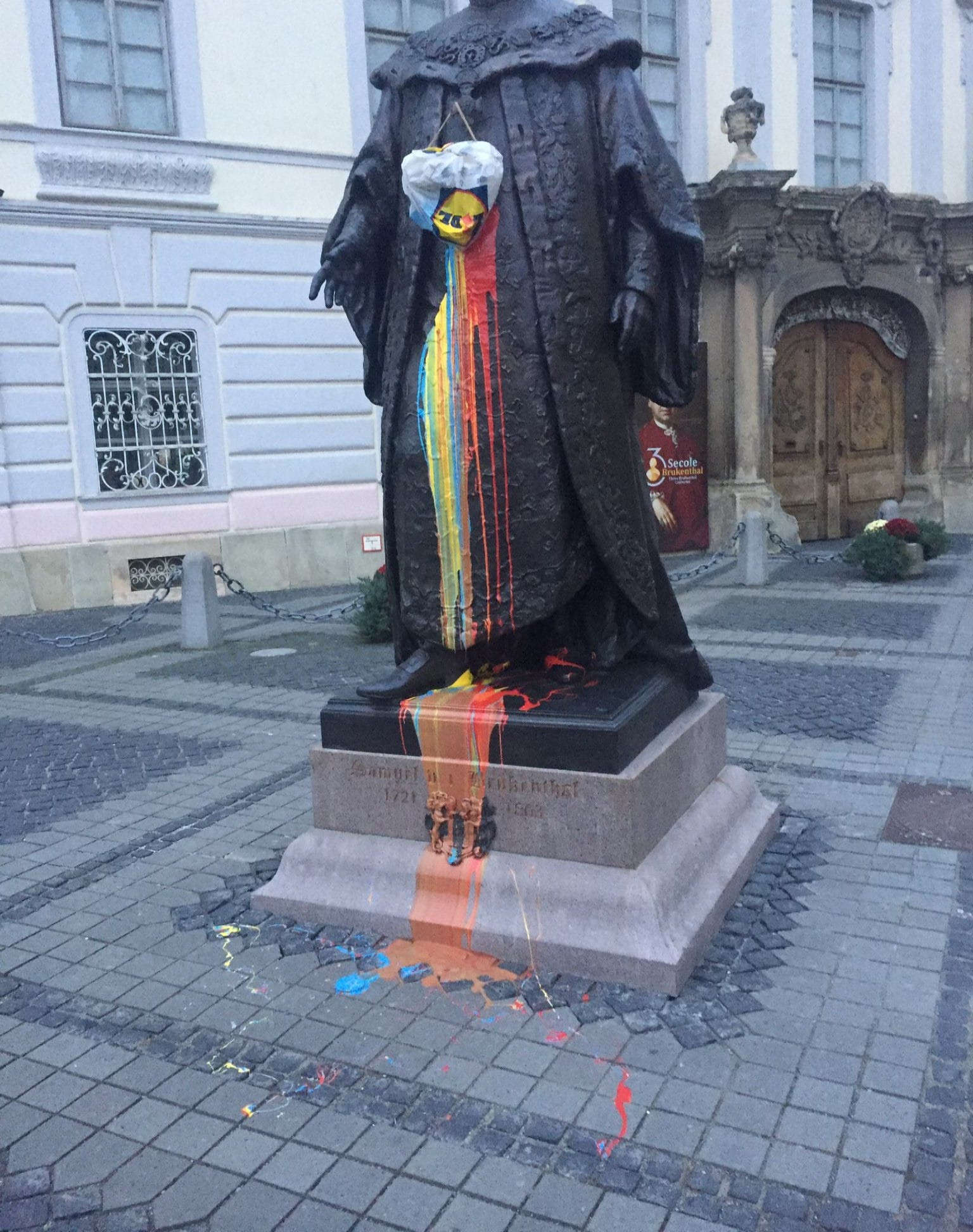 Statuia lui Brukenthal din centrul Sibiului, vandalizată în culorile tricolorului. Autorul a fost filmat