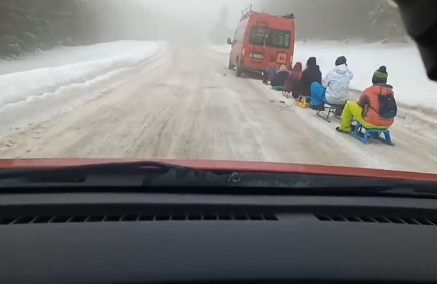 Șoferul unui microbuz, filmat în timp ce trăgea mai mulți copii pe sănii, în Caraș-Severin. VIDEO