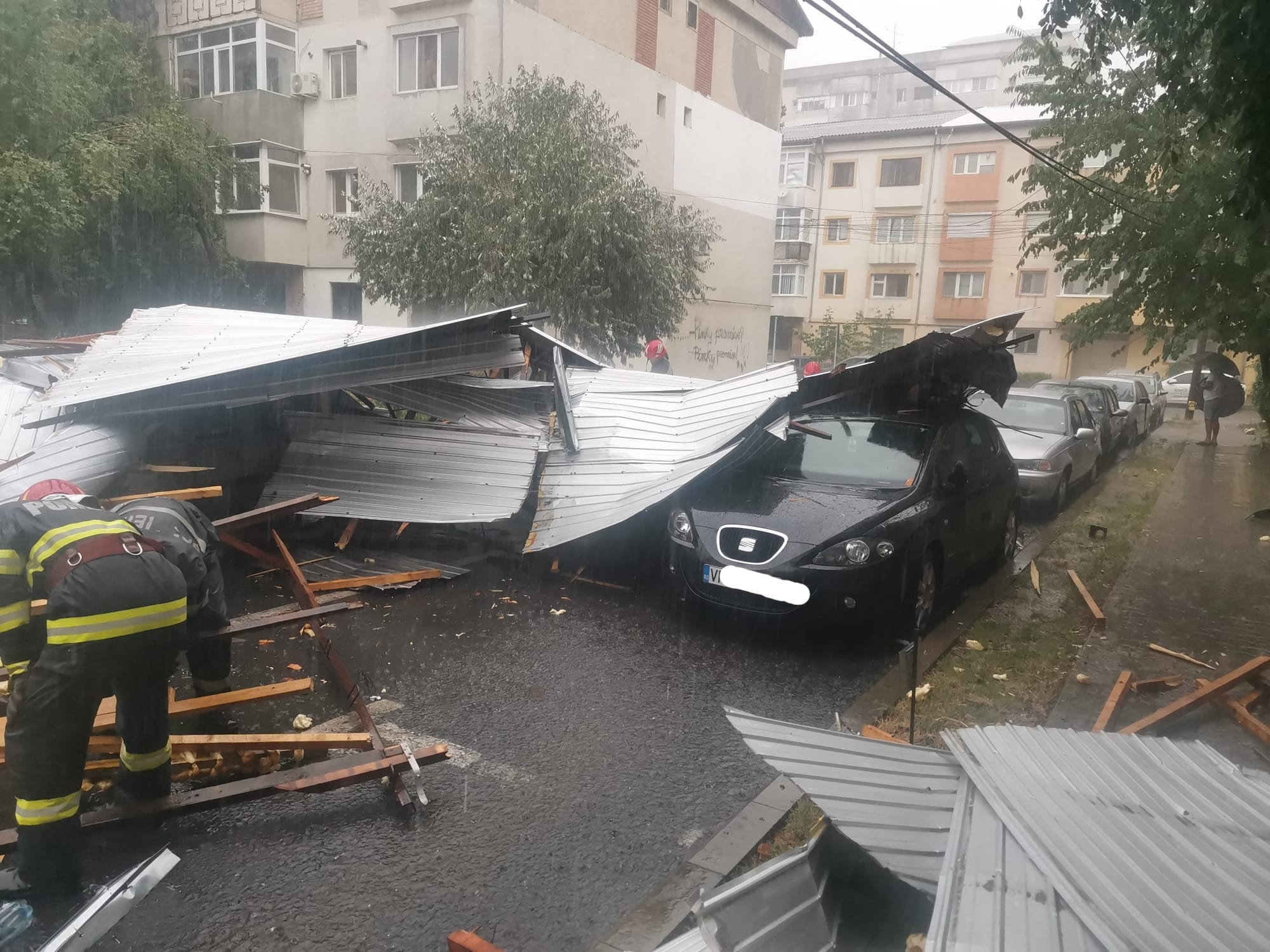 Un acoperiş şi arbori căzuţi peste autoturisme, în urma fenomenelor meteo extreme, la Focşani | GALERIE FOTO