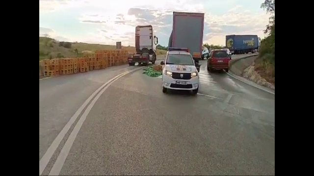 Zeci de lăzi de bere s-au împrăștiat pe DN 65. Șoferul nu asigurase marfa