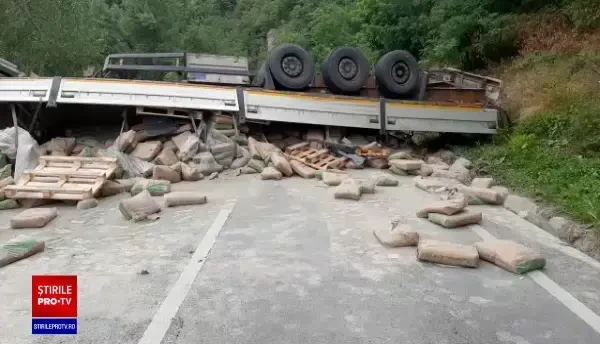 VIDEO Un TIR încărcat cu ciment s-a răsturnat în Bumbești Jiu. Traficul este complet blocat