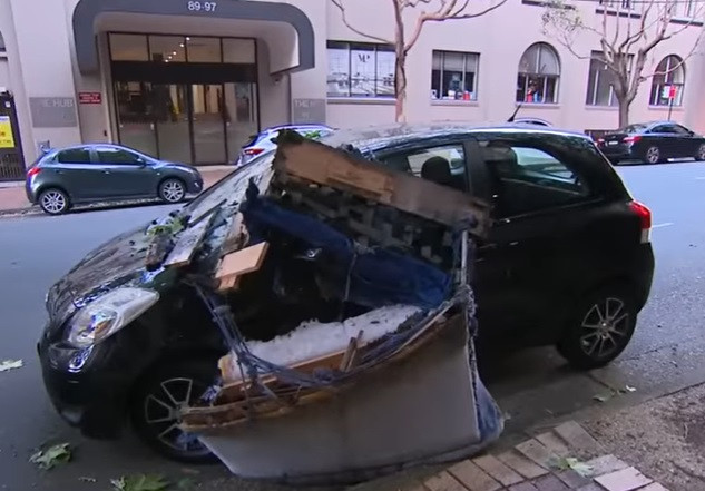 A coborât să facă niște plăți și o canapea i-a aterizat fix pe mașină. Ce cred polițiștii că s-a întâmplat. VIDEO