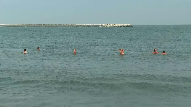 Temperaturi record pentru luna decembrie la malul mării. Mai mulți bărbați s-au aventurat la o baie în mare