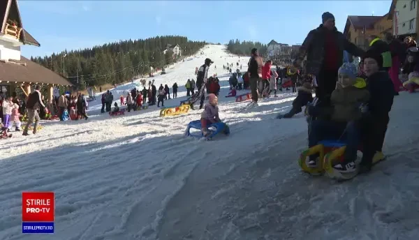 Pârtiile cu zăpadă artificială au fost luate cu asalt de turiști. Săniuțele abia au avut loc pe sectorul alocat copiilor