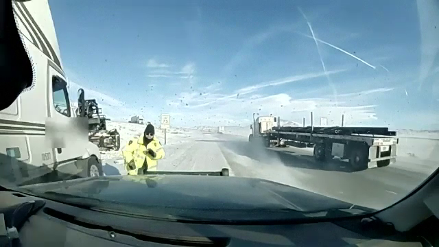 Momentul în care un polițist scapă în ultima clipă de un camion derapat pe o șosea înzăpezită