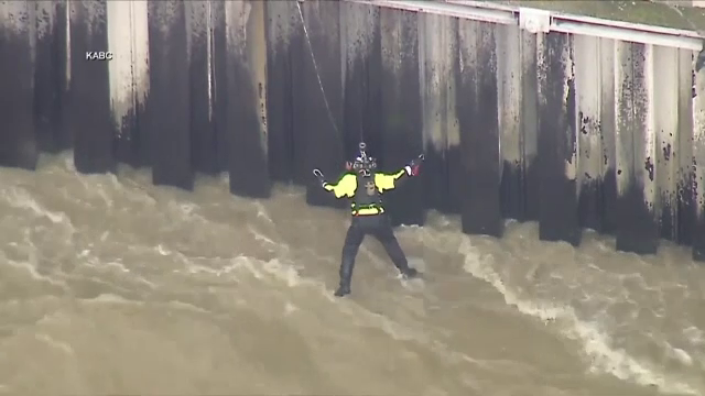 Momentul în care un bărbat agățat de peretele de beton al unui canal este salvat de pompieri. Pe sub el trecea un râu | VIDEO