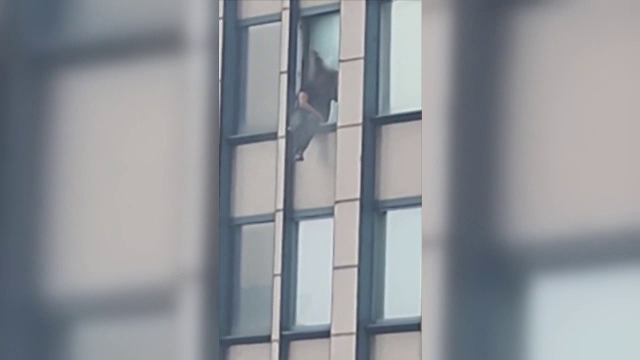 Un bărbat căutat de FBI a stat ore întregi agățat de un geam de la etajul 30 amenințând că se sinucide