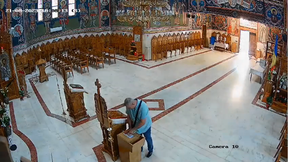 Momentul în care un bărbat fură bani din cutia milei, într-o biserică din București. Înainte, face cruce, să-l ajute Dumnezeu