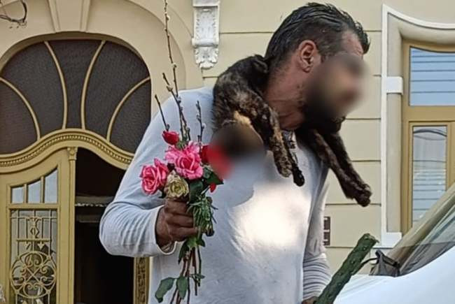 Apariție ciudată &icirc;n Arad. Un bărbat se plimba cu o pisică moartă la g&acirc;t, un buchet de flori și m&acirc;nca dintr-un cactus