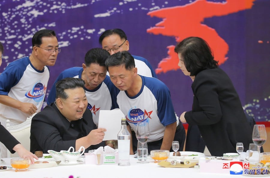 Kim Jong Un a dat un banchet somptuos ca să celebreze lansarea satelitului de spionaj. Au purtat tricouri cu „NATA”. FOTO