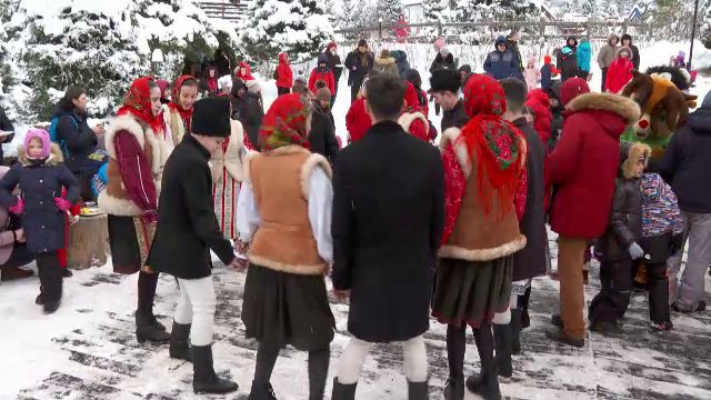 Distracție la munte în Ajunul Crăciunului. Zeci de turiști din Bran și-au început ziua cu pomana porcului și au dansat hore
