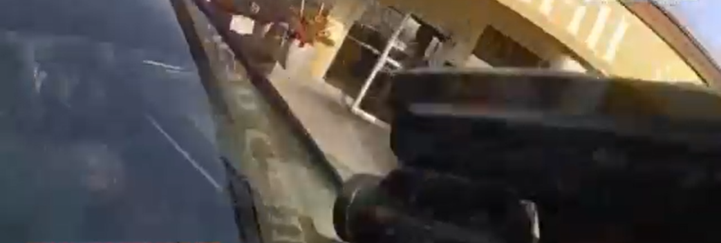 Momentul în care șoferul unei mașini furate ia pe capotă un polițist în timp ce agentul îl împușcă
