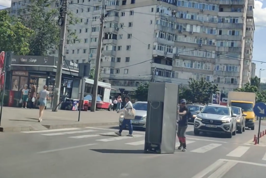 Imagini bizare cu un ieșean care împinge liniștit un frigider printre mașini, în mijlocul unei intersecții aglomerate | VIDEO