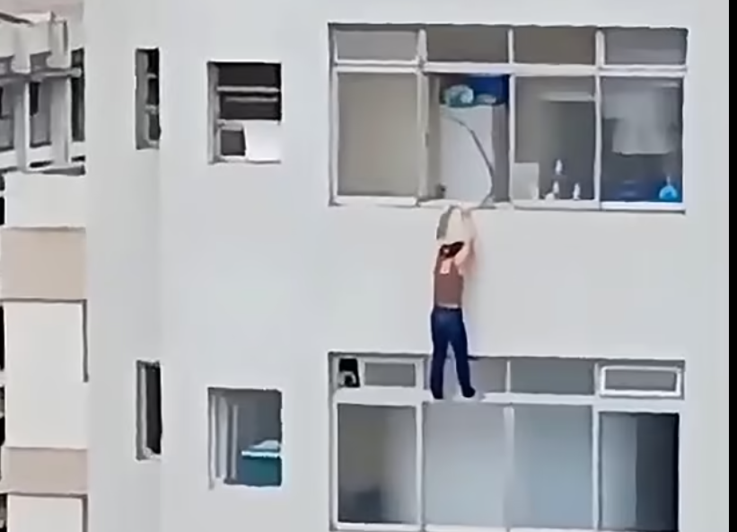Momentul șocant în care o femeie stă agățată de un pervaz de la etajul 16, după ce a alunecat în timp ce ștergea geamurile