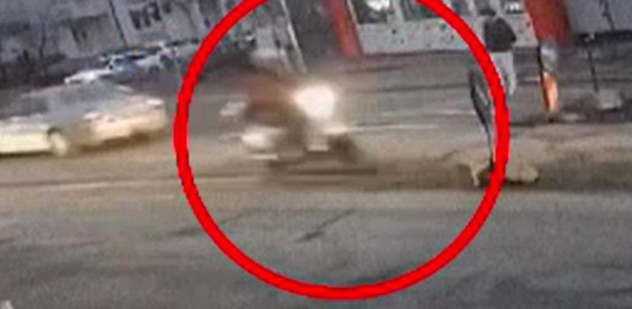 Momentul în care un livrator ajunge cu scuterul într-un indicator rutier de pe drum. Singura „victimă”, în rucsac