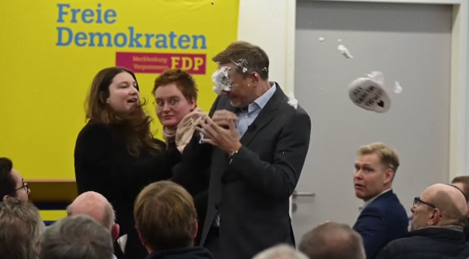 Un politician de rang înalt a fost atacat de o femeie din public cu o farfurie plină cu spumă