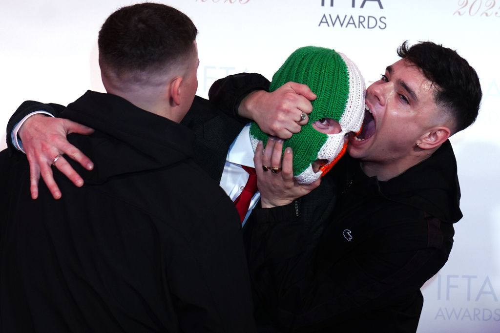 Un membru al formației de rap Kneecap este acuzat de terorism în Marea Britanie, după ce a adus un steag Hezbollah pe scenă