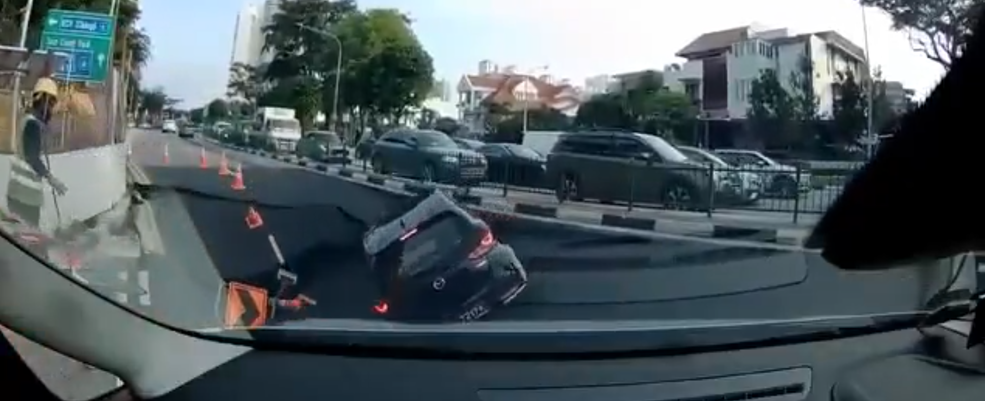 O groapă uriașă a înghițit o mașină pe o stradă din Singapore, acolo unde David Popovici concurează la Campionatul Mondial